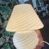 Murano lampe som bliver holdt i hånden og lyser, så man kan se detaljerne i glasset